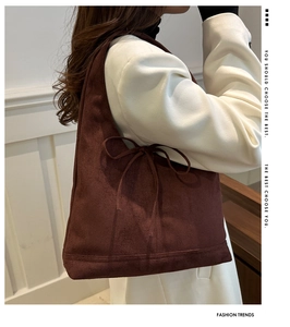 Detail of the brown suede tote bag featuring a decorative side drawstring bow design