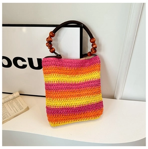 Detail view of handmade rainbow straw tote bag featuring colorful stripes and wooden bead handles