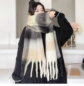 Detail of the thick grey and white gradient scarf with cozy fringed tassels and soft texture