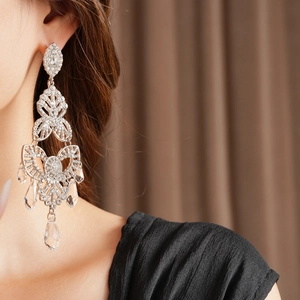 Close-up of sparkling silver drop tassel earrings with crystals on female model