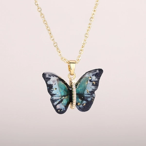 Gold butterfly pendant necklace with blue-green gradient resin wings and fine crystals