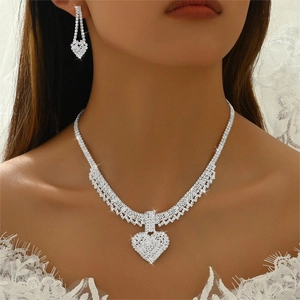 Detail of silver bridal jewelry set with heart crystal pendant and matching earrings