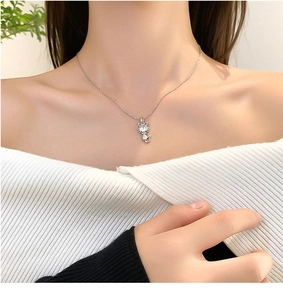 Silver cat pendant necklace featuring a sparkling zircon stone worn on a model's neck