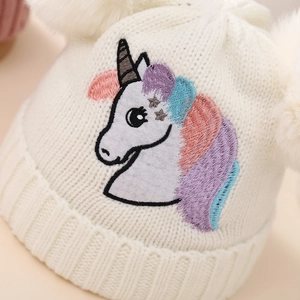 White winter knitted baby hat with colorful unicorn embroidery and double pom-poms