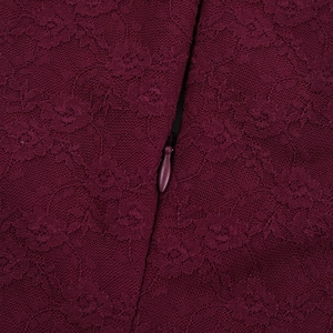 Détail du tissu en dentelle bordeaux avec fermeture éclair invisible sur la robe