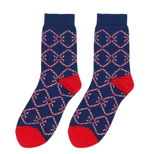Detail of navy blue and red knit Christmas socks with geometric diamond pattern texture