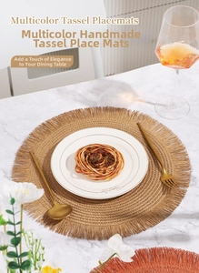 Dettaglio della tovaglietta intrecciata con nappe dorate su tavolo di marmo bianco