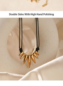 Detail of high hand polished gold spike necklace on elegant silk background