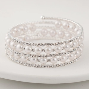 Detailed macro view of multi-layer stretch bracelet with white pearls and sparkling rhinestones