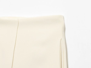 Gros plan détaillé du pantalon de costume beige montrant les coutures et la texture du tissu