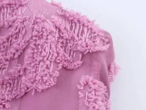 Close-up of purple textured fabric with mesh and floral embroidery detail for elegant dress