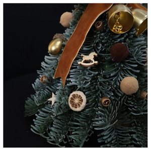 Macro detail of handmade mini Christmas tree with gold bells and velvet ribbons