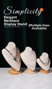 Three-piece beige linen necklace display stand with natural wooden base on velvet