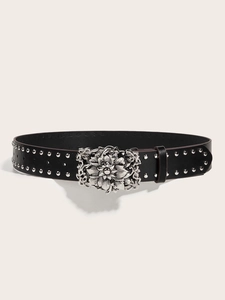 Detail of black leather belt with silver flower carved buckle and punk style studs