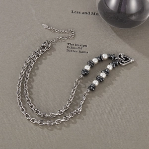 Detailed macro view of silver titanium steel double chain with heart clasp and pearls