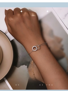 Close-up of interlocking silver double ring bracelet with zircon inlay worn on wrist
