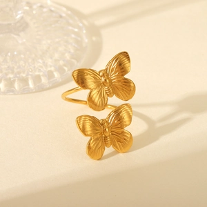 Detailed close-up of golden butterfly ring with fine brushed texture and open design