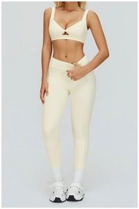 Dettaglio del set yoga crema con reggiseno con scollo a V incrociato e leggings