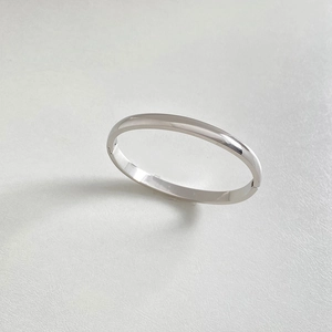 Close-up of polished silver stainless steel hinged bangle with mirror finish