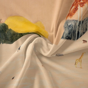 Detail of bohemian tapestry fabric with giraffe print and silky texture in spiral folds