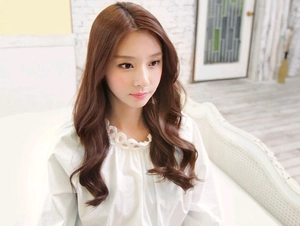 Detailed view of brown long curly hair extensions on a model for a natural look