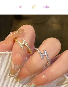 Gros plan d'un mannequin portant des bagues H en or et argent serties de zircons brillants