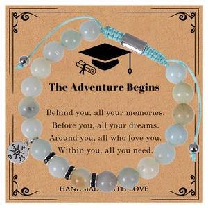 Detail of pink zebra stone graduation bracelet with compass charm on quote card