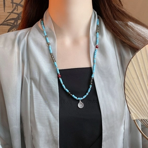 Detail of New Chinese style beaded necklace with turquoise stones and silver pendant