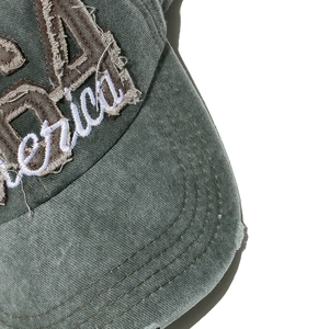 Detail of vintage washed denim America 1964 embroidery and distressed frayed cap brim