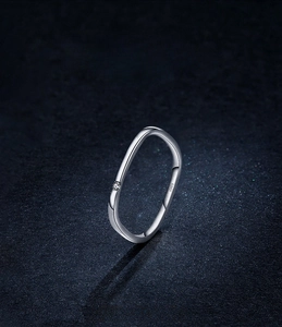 Macro detail of S925 sterling silver ring featuring a wavy band and a single round diamond