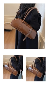 Detail of dark brown baguette bag with adjustable strap and metallic buckle decoration