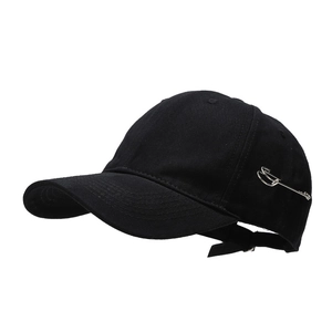 Minimalist black cotton baseball cap featuring a distinctive silver metal safety pin detail