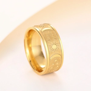 Macro shot of gold celestial ring featuring embossed sun moon and star patterns