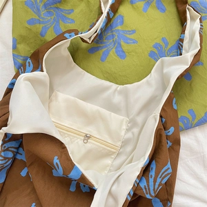 Close-up of the internal zipper pocket and smooth white lining of the floral canvas tote