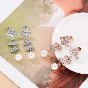 Detailed view of layered fan-shaped earrings with shimmering zircons and white pearls