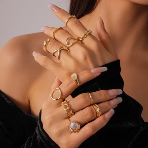 Detail of 12-piece gold geometric ring set with baroque pearl on female model