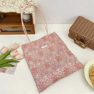 Flat lay of pink floral canvas tote bag with rustic picnic props and fresh tulips