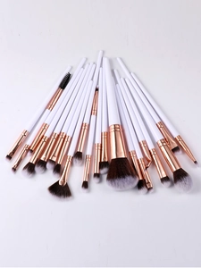 Detailed spread of 20 professional makeup brushes with white handles and rose gold ferrules