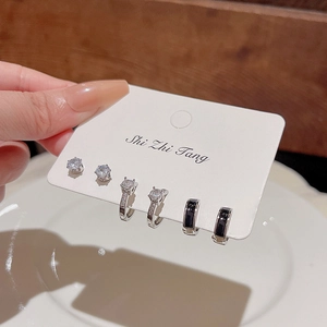 Macro detail of 6-piece silver earring set with cat eye stones and small pearls