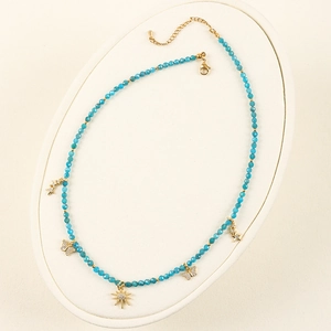 Detail of bohemian blue beaded necklace with gold sun, star and butterfly pendants