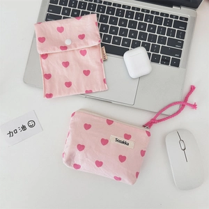 Close-up of pink heart-patterned fabric pouches with zipper and snap button closure