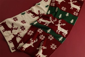 Detail of knitted Christmas scarves with reindeer and snowflake patterns in festive colors