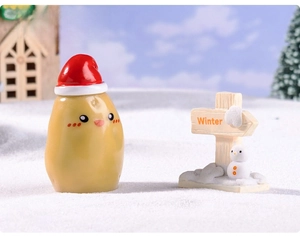 Miniature Christmas potato figurine with winter sign and snowman in snow scene