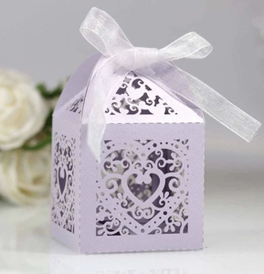 Detail of lavender laser-cut heart candy box with elegant white ribbon for wedding gifts