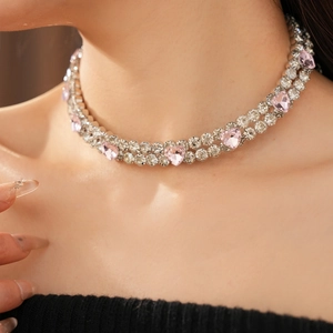 Gros plan d'un collier double couche avec strass en forme de cœur rose sur modèle