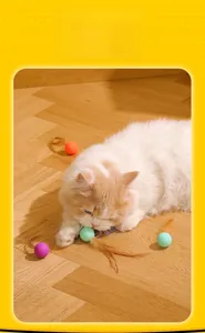 Action shot of a cat playing with a silicone feather ball on a wooden floor