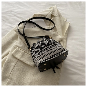 Detail of vintage drawstring bucket bag featuring black and white geometric woven fabric