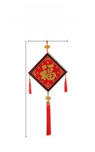 Vue détaillée d'un nœud chinois rouge et doré avec caractère Fu et longues franges
