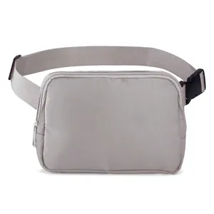Detail of light gray nylon fanny pack with adjustable strap and metal zipper closure