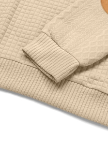 Detail of beige quilted waffle texture and ribbed cuffs on a long sleeve sweatshirt